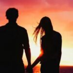 couple holding hands at sunset — long distance love poems