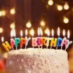 Birthday poem beside a birthday cake with lit candles