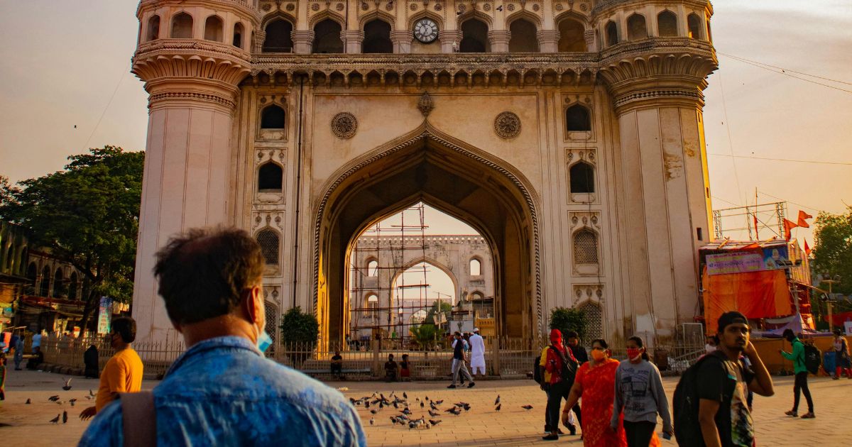 The Bazaars of Hyderabad poem setting — Charminar archway with crowds at golden hour in the old city.